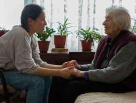 Woman holding older person's hands